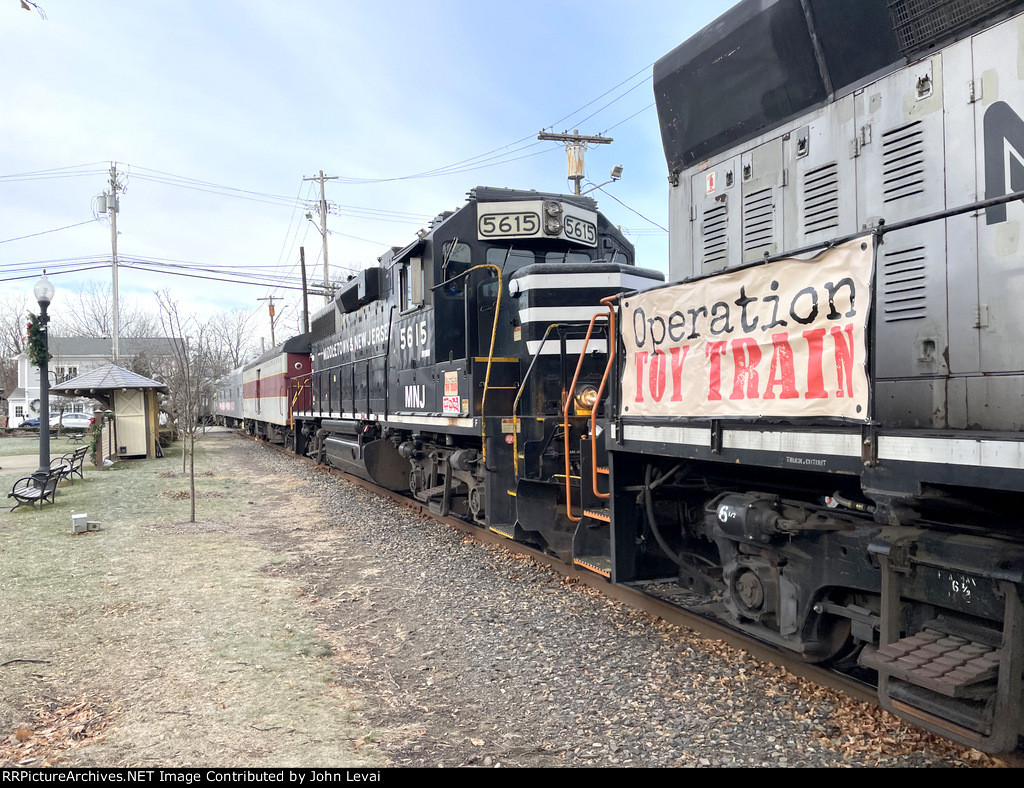 M&NJ TFT Train backing to connect to part of the train that was stored on the other side of the grade crossing in the background